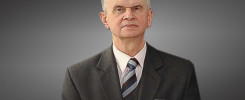 Portret starszego mężczyzny w garniturze i krawacie.