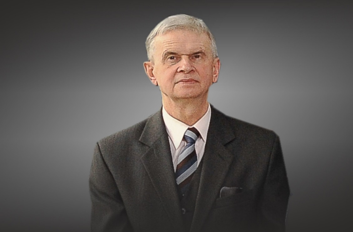 Portret starszego mężczyzny w garniturze i krawacie.
