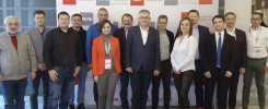 Grupa osób pozuje do zdjęcia na tle banera Politechniki Świętokrzyskiej. Kluczowe obiekty: ludzie, baner.