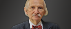 Portret starszego mężczyzny w garniturze i muszce. Kluczowe obiekty: mężczyzna, garnitur, muszka. Kontekst: formalny.