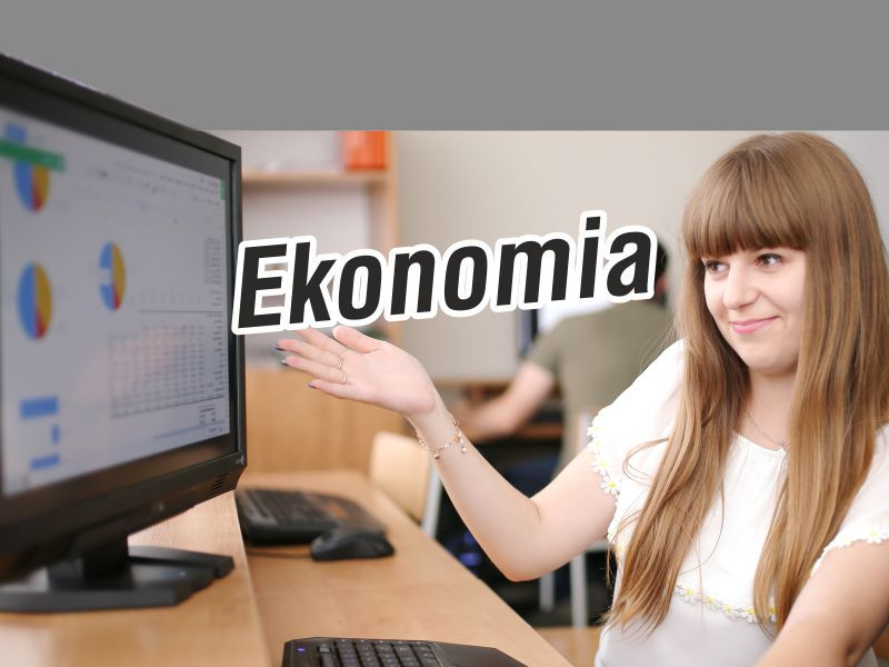 Kobieta wskazuje na ekran komputera z wykresem. Napis "Ekonomia". Kontekst: nauka, prezentacja.